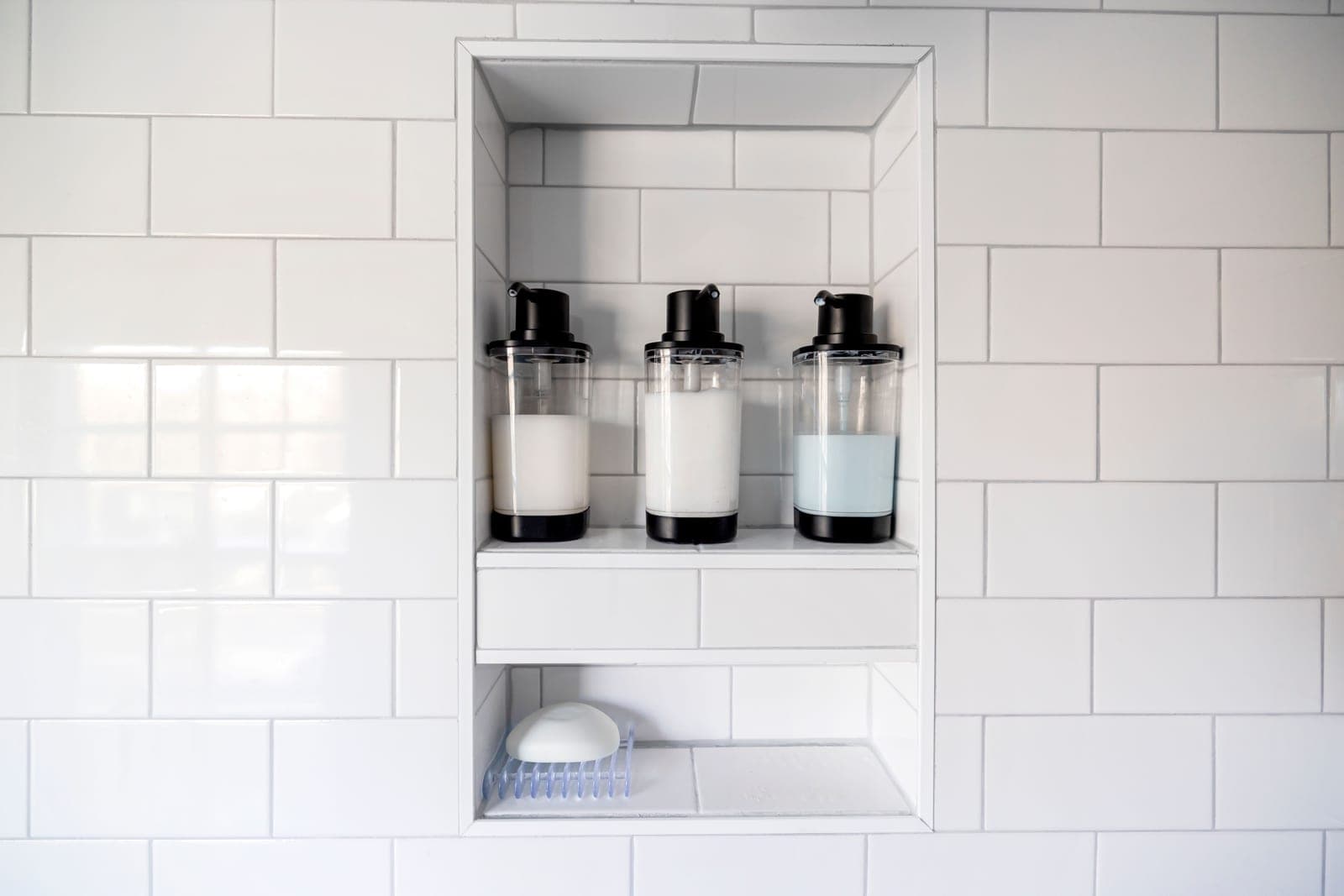 A shower caddy holding bottles in a tiled shower