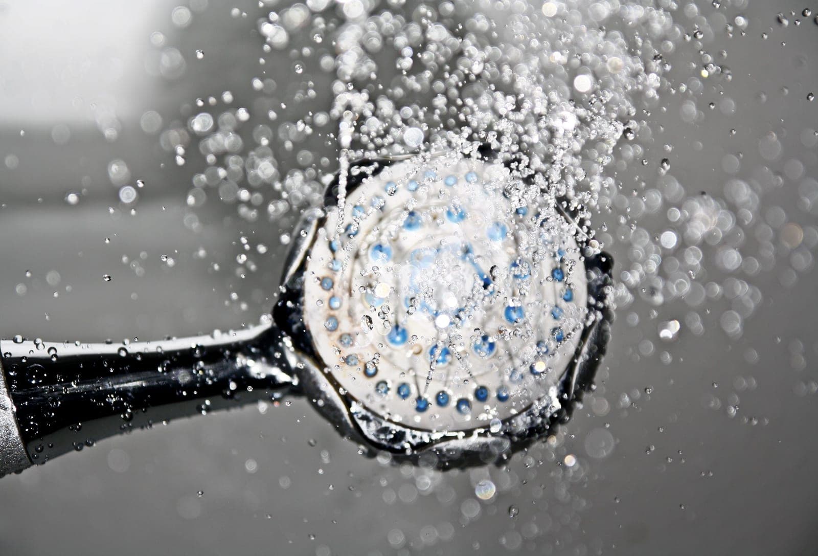 Close-up of clear water droplets falling from a shower