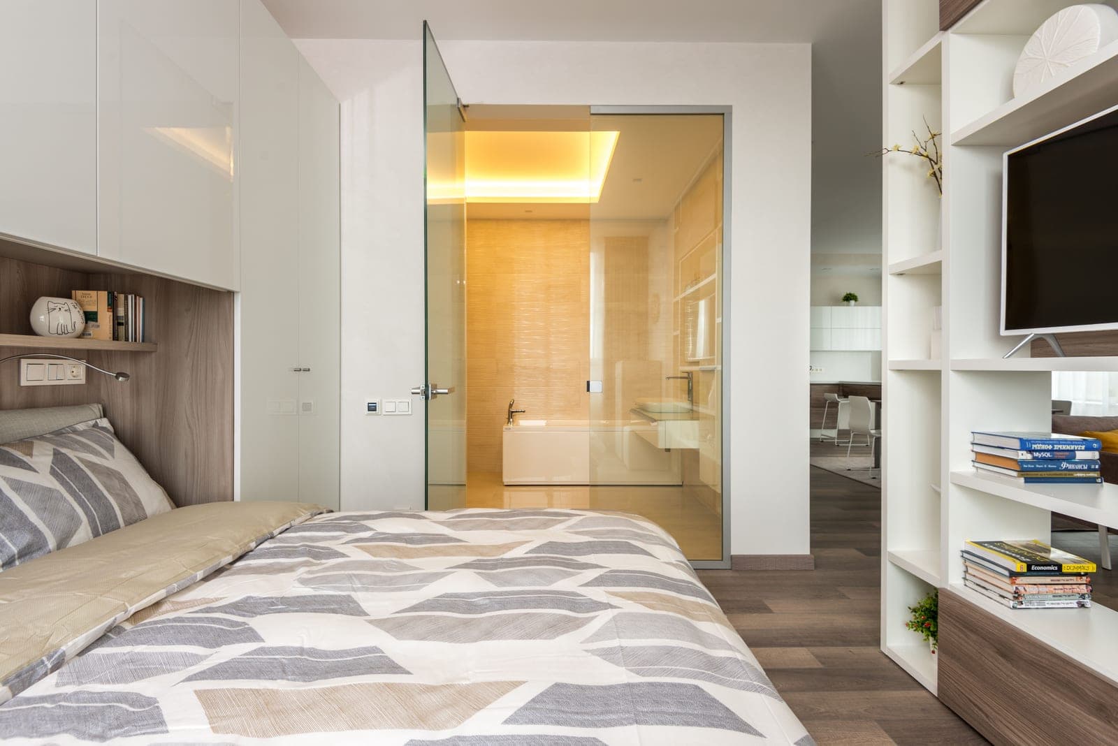 A small, bright apartment bathroom with pale tile